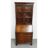 Mahogany bureau bookcase with a dentil cornice over a pair of glazed doors above a fall front and