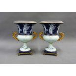 A pair of continental porcelain campana urn vases with winged cherub pattern, on square gilt metal