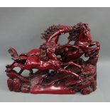 Red resin figure group of horses on naturalistic base, 41 x 30cm