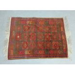 Eastern rug, the red field with three rows of six square medallions, geometric borders, 125 x 90cm