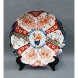 Imari scalloped charger painted with a basket of flowers centre, with a plate hanger in situ, 30cm
