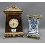 Modern mantle clock and blue and white vase on metal base, 920