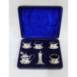 George V silver cruet set, comprising four salts, mustard and pepper, pot with condiment spoons,