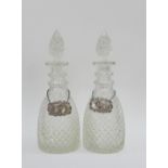 A pair of triple ring neck decanters and stoppers with silver Sherry and Port decanter labels,