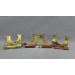 Three pairs of Victorian style brass flat boots on wooden stands, 17cm (6)