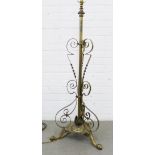 Adjustable brass standard lamp with a tripod base and scroll decoration, 128cm