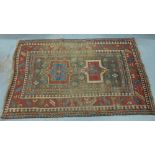 Kazak rug, the worn rust field with two geometric medallions within multiple borders, 216 x 138cm (