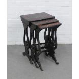 Nest of three ebonised tables with chinoiserie patterned tops and lyre style side supports,