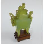 Chinese jade Koro and cover with Kylin finial and stylised pierced handles, on a wooden stand,