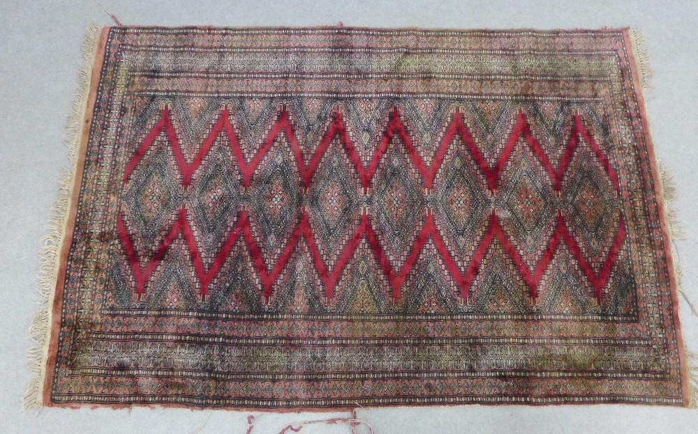 Easter rug with red zig zag pattern within multiple geometric borders, 186 x 128cm