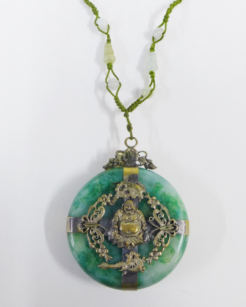 Early 20th century jadeite Buddhist pendant of disc form with filigree mounts, 6cm