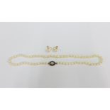 Strand of pearls with a yellow metal garnet and pearl cluster clasp, largest pearl approx 1cm,