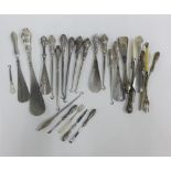 A collection of silver and white metal handled button hooks, shoe horns and pickle forks, etc (a