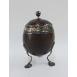 Georgian coconut cup and silver with silver rim and mounts, on three shell feet, 19cm high