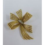 18ct gold and diamond brooch of tied bow design with a textured finish, stamped 18K, 5cm (approx