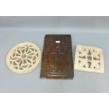 Carved wooden plaque with a cross pattern, 47 x 28cm, and two pierced terracotta roundel, 33cm , (