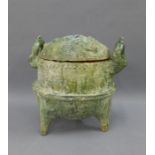 Chinese green glazed Han type cooking vessel with loop handles, stile feet and a domed cover, 27cm