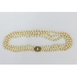 A vintage triple strand cultured pearl necklace with an 18ct gold and diamond set clasp, of