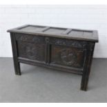 Dark oak coffer with three panelled lid, floral carved front panel and a void interior, 102 x61