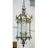 A large brass hanging lantern light with domed top and urn finials, over engraved glass panels, with