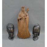 Carved wooden figure of a Saint and two African ebonised wooden heads, tallest 35cm (3)