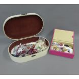 A floral painted wooden box containing a quantity of modern costume jewellery brooches and beads,