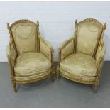 A pair of French style gilt gesso armchairs with a ribbon tied foliate top rail, upholstered back,