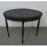 Dark oak side table with an oval top with carved border, (top warped) 93 x 73 x 58cm