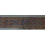 Kazak style runner, with eight geometric medallions within multiple borders, 400 x 90cm