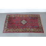 Eastern rug with a red field and central medallion and multiple borders, 184 x 104cm