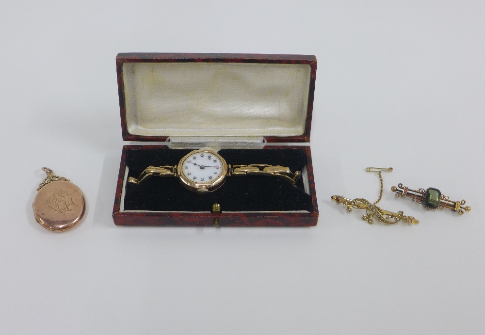 Two early 20th century 9ct gold brooches and a lady's vintage 9ct gold cased wristwatch on a 9ct