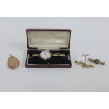 Two early 20th century 9ct gold brooches and a lady's vintage 9ct gold cased wristwatch on a 9ct