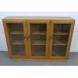 An Ercol light elm bookcase with three glazed doors, 136 x 98 x 31cm