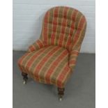 Upholstered chair on mahogany legs with brass caps and ceramic castors,