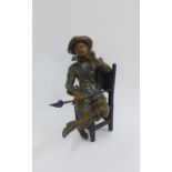 Bronze patinated metal figure of a Cavalier, modelled seated on a high back chair, 26cm high