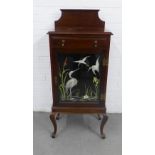 Mahogany ledgeback cabinet, with a single drawer over a cupboard door with a n embroidered panel