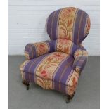 Late 19th / early 20th century upholstered spoonback armchair, on carved mahogany legs with brass