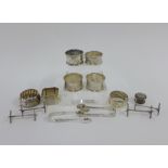 A quantity of silver napkin rings, silver sugar tongs and silver knife rests, various hallmarks (a