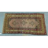 Eastern rug, the central panel with an ivory field and three medallions within flowerhead borders,