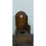 A child's antique oak / elm commode with a heart shaped cut out to the back panel, 34 x 58 x 34cm