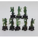 Chinese jade set of eight Immortals, modelled standing on a pierced hardwood base, tallest 6cm (8)