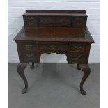 A carved oak writing desk, with stationery rack to the superstructure, rectangular top over a pull