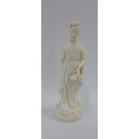 Blanc de chine female figure, modelled standing carrying a basket of leaves, 26cm high