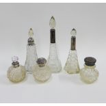 A collection of six cut glass bottles with silver and white metal collars and covers, (6)