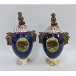 Pair of continental urn vases with mask head handles and pierced covers, (one cover with