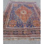Eastern rug with a blue field and terracotta diamond lozenge and flowerhead motif to centre,