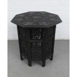 An oak leaf carved Benares type table with an octagonal top and folding base, 55 x 55cm