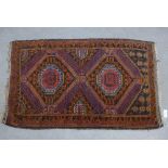 Eastern rug, the terracotta field with two octagonal medallions, geometric border, 143 x 67vm