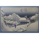 Japanese School woodblock of figures walking in the heavy snow, framed under glass with a Tokyo