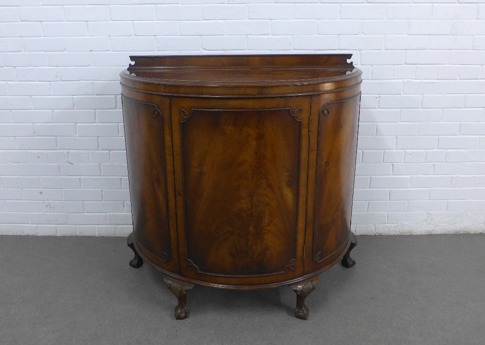 Mahogany bow front cabinet with a ledgeback, single door and shelved interior, on cabriole legs with